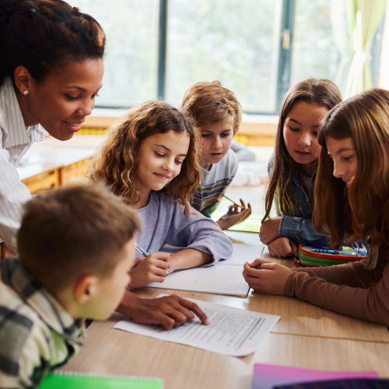 Teacher helping a table of students with work